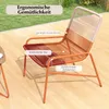 An outdoor chair and table set on a wooden deck with grass in the background. Náhled obrázku produktu