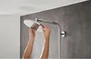 Hands adjusting a shower head in a modern bathroom. Anteprima dell’immagine prodotto