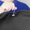A person's hand holding a hanger hook attached to a black garment bag. Anteprima dell’immagine prodotto