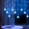 Snowflake string lights are hung in a window at night, with a table in the foreground. Náhled obrázku produktu