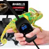 A hand holding a reptile heating pad with a thermostat, with a chameleon in the background. Voir les images du produit