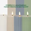 Four LED candles in different colors are displayed against a background of vertical color stripes. Podgląd zdjęcia produktu