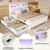 A white bed with a pull-out trundle bed, featuring LED lighting and storage compartments in the headboard. Produktbild-Vorschau