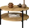 A two-tiered round coffee table with decorative items on top and books on the bottom shelf. Náhľad obrázku produktu