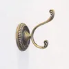 A single bronze vintage-style wall hook mounted on a textured white wall. Produktbild-Vorschau