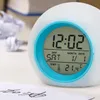 A digital alarm clock is shown on a desk with some crumpled paper in the background. Produktbild-Vorschau