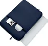 A navy blue laptop sleeve with a pocket holding a smartphone and a white object, partially covering a white laptop. Anteprima dell’immagine prodotto