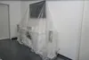 A TV and entertainment center covered in a clear plastic sheet, likely for protection during moving or renovation. Produktbild-Vorschau