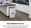 A modern kitchen with white cabinets and a wooden countertop, featuring a multi-compartment trash can. Produktbild-Vorschau