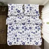 A top-down view of a bed with blue and white floral patterned bedding. Produktbild-Vorschau