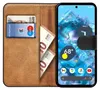 A book-style phone case with a Google Pixel 8a inside, showing the phone's screen and the case's card and money slots. Produktbild-Vorschau