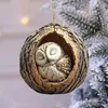 A sleeping owl ornament nestled in a tree bark hollow, hanging on a frosted Christmas tree. Produktbild-Vorschau