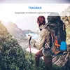 A hiker with a large backpack stands on a mountain trail, looking out at a scenic view of a lake and mountains. Produktbild-Vorschau