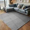 A sectional sofa with decorative pillows is placed on a rug in a living room. Produktbild-Vorschau