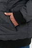 A close-up shot of a person's hand in the pocket of a dark gray winter jacket. Produktbild-Vorschau