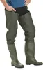 A person wearing olive green waders and a blue shirt, standing against a white background. Produktbild-Vorschau