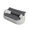 A white woven outdoor sofa with gray cushions and two small accent pillows, one cream and one white, on a white background. Produktbild-Vorschau