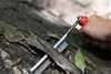 A hand holding a tool and using it to shave bark off a log. Podgląd zdjęcia produktu