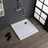 A square shower tray is shown on a wooden floor next to a dark gray wall with a shower head mounted on it. There are also a pair of black flip-flops on the floor. Produktbild-Vorschau