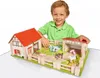 A young boy is playing with a toy farm set. Anteprima dell’immagine prodotto