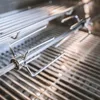 Close-up view of a stainless steel rotisserie spit and forks inside a grill. Podgląd zdjęcia produktu