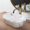 A close-up shot of a marble-patterned vessel sink with a gold faucet. Podgląd zdjęcia produktu