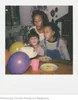 A family celebrating a birthday with a cake and balloons. Produktbild-Vorschau