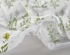 A close-up view of a white duvet cover with a green floral pattern and an open zipper. Produktbild-Vorschau