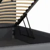 A close-up view of the internal mechanism of a bed frame, showing the lifting gas struts and the wooden slats of the mattress support. Produktbild-Vorschau