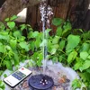 A solar-powered fountain pump with LED lights is operating in a garden pond surrounded by lush green plants. Podgląd zdjęcia produktu