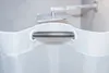 A close-up of a white shower curtain with a metal rod going through its grommets, with a shower head visible in the blurred background. Podgląd zdjęcia produktu