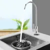 A chrome faucet is dispensing water into a sink where a colander with two puppies is being rinsed. Produktbild-Vorschau