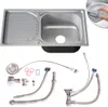 A stainless steel kitchen sink with a drainboard and various plumbing accessories laid out below it.
