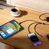 A charging cable is connected to a tablet and a smartphone on a wooden table, with a cup of tea nearby. Produktbild-Vorschau