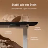 A desk with a rock and a glass of water on it, highlighting its stability. Voir les images du produit