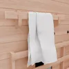A close-up shot of a white towel hanging on a wooden towel rack mounted on a wooden wall. Produktbild-Vorschau