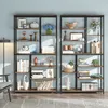 Two tall, modern, industrial-style bookshelves filled with decorative items and books, placed against a light blue wall. Podgląd zdjęcia produktu