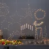 A collection of LED Christmas decorations, including stars, a wreath, a reindeer, and a Christmas tree, displayed on a table. Produktbild-Vorschau