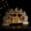 A wooden Christmas arch with a village scene illuminated by warm white LEDs. Náhľad obrázku produktu