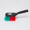 A cleaning brush with a black handle and teal and red bristles, set against a plain white background. Produktbild-Vorschau
