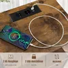 A close-up of a wooden table surface with a built-in power strip and a smartphone charging. Produktbild-Vorschau