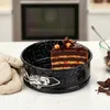 A slice of chocolate cake is displayed in a black speckled springform pan on a countertop. Anteprima dell’immagine prodotto
