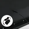 A close-up view of the back of a black electronic device, showing a power adapter and cable plugged into a port. Podgląd zdjęcia produktu