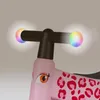 A close-up of the handlebars and front of a pink balance bike with leopard print. Náhled obrázku produktu