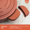 A close-up of a pot lid with silicone handle covers, placed on a wooden surface. Produktbild-Vorschau