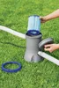 A pool filter pump with a filter cartridge being inserted, set up on a grassy lawn. Produktbild-Vorschau