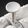 A close-up shot of a white kitchen gadget with a reflective circular component. Podgląd zdjęcia produktu