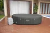An inflatable hot tub and its pump are set up on a wooden deck next to a swimming pool and a house. Produktbild-Vorschau