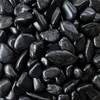 Schwarze polierte Kieselsteine dicht aneinander liegend im Detail Produktbild-Vorschau
