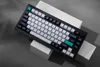 A mechanical keyboard is displayed on geometric blocks against a gray background. Voir les images du produit